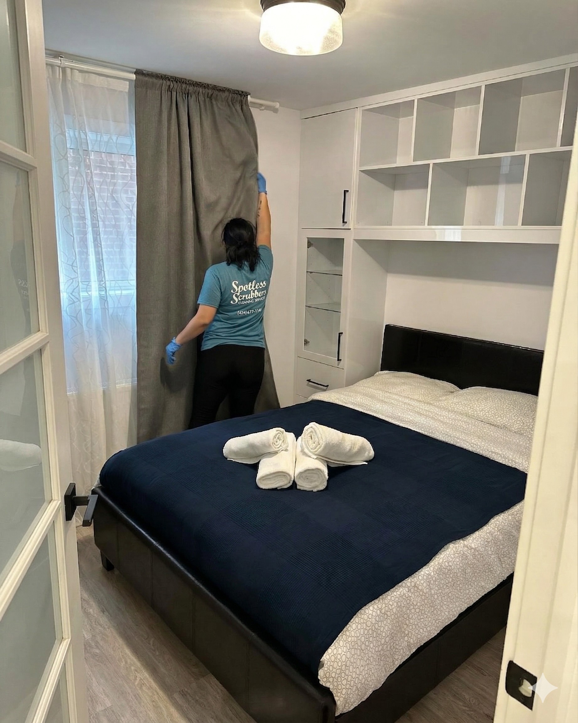 Team member preparing Airbnb bedroom with fresh towels